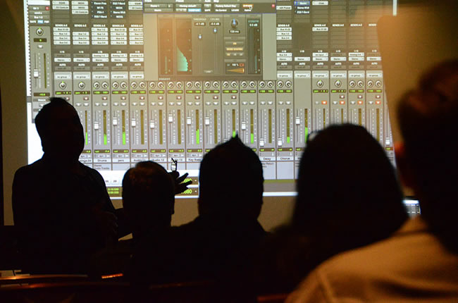 TAXI members silhouetted against a screen during one of several breakout classes about music recording at the Rally.
