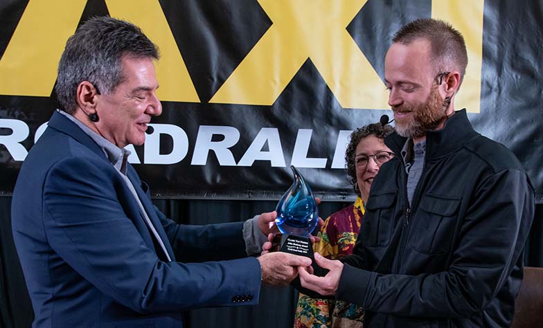 TAXI Member Clark Van Norris (right) was presented the John Braheny Songwriting Award by Michael Laskow with JoAnn Braheny proudly watching the presentation.