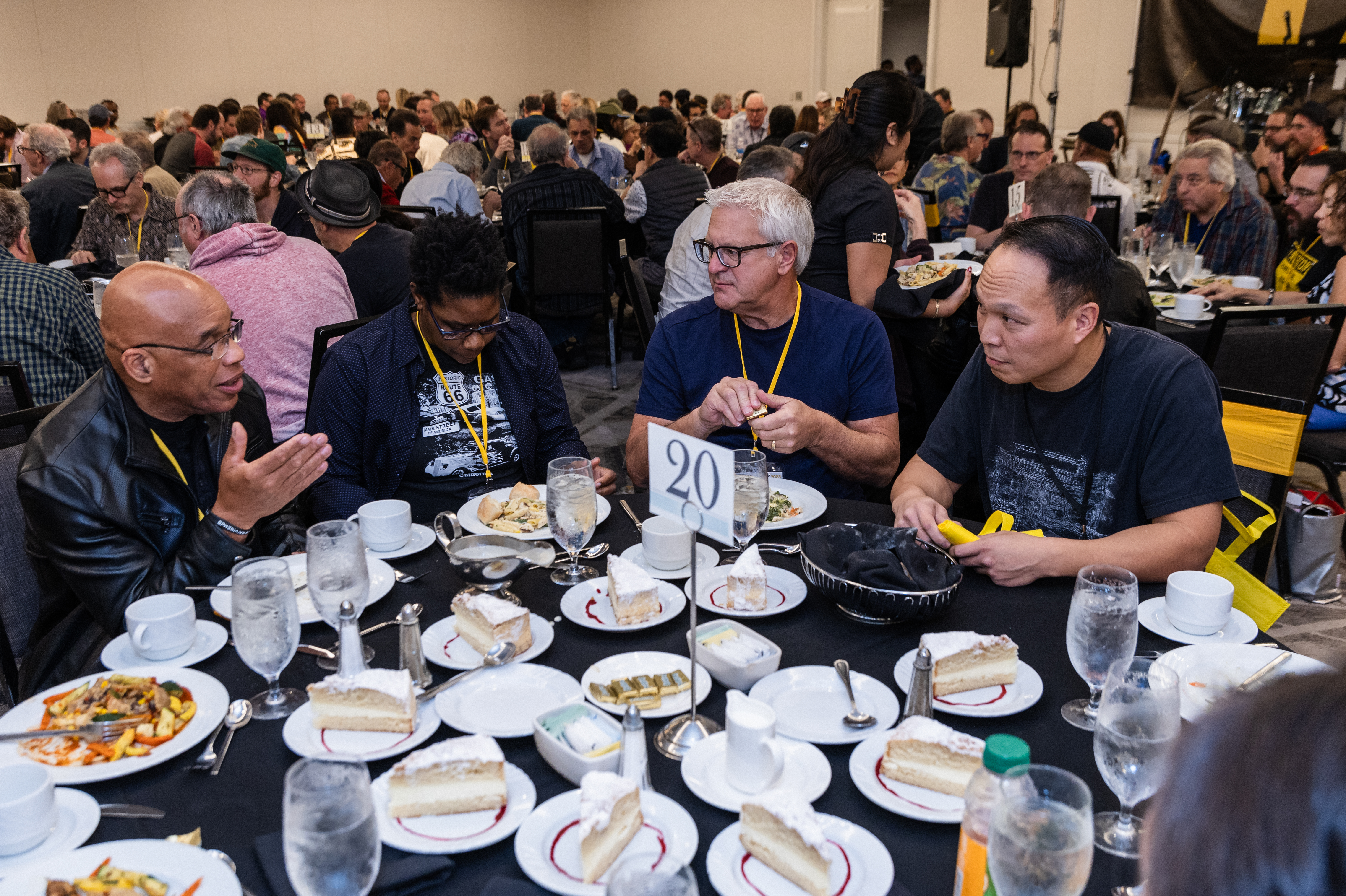 Mentor, Owen Chaim (far right) discussing something really important because nobody has touched their dessert yet during this Eat & Greet Luncheon.