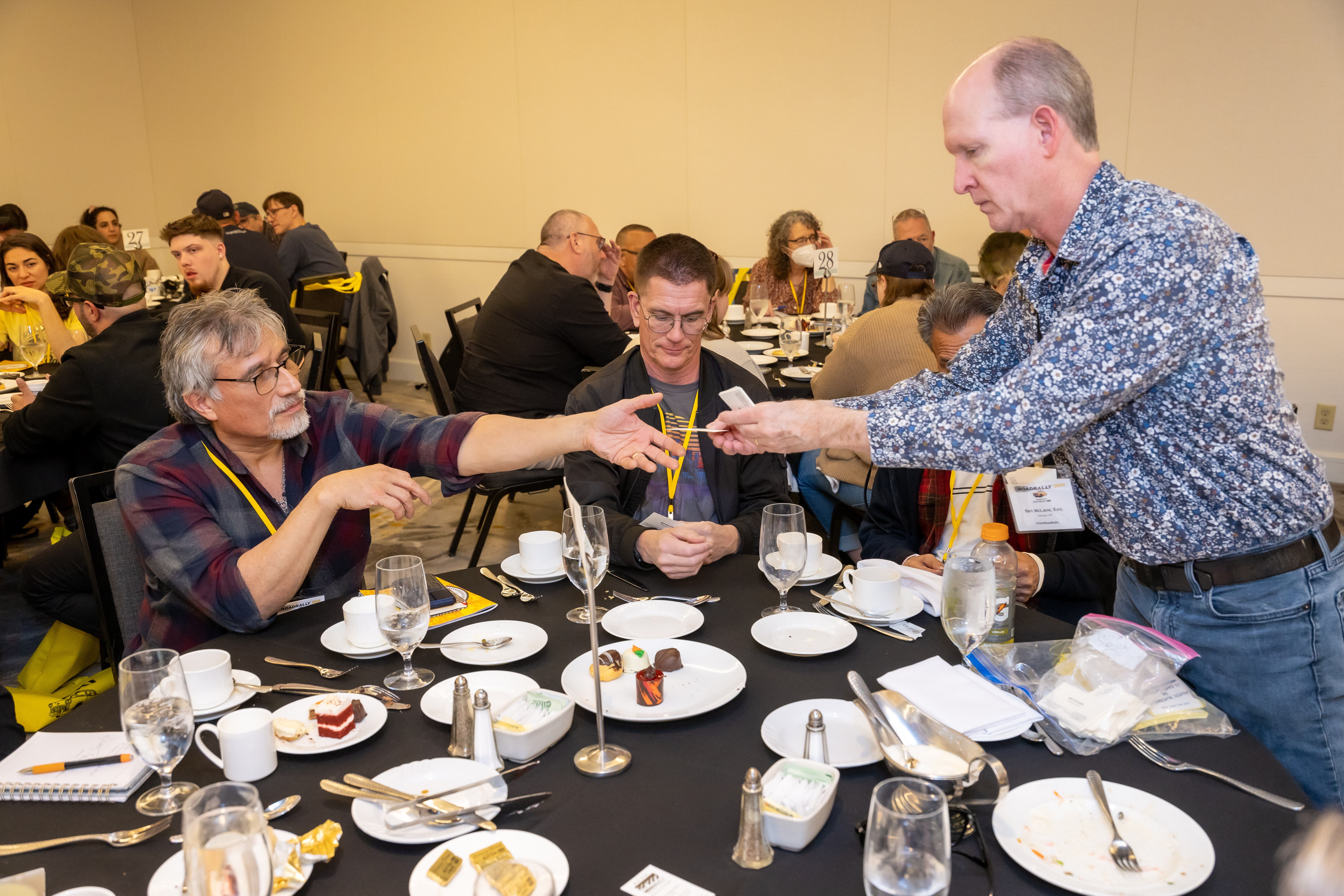 Music attorney Ben McClain (standing) exchanging contact information with a TAXI member at the Eat & Greet Luncheon.